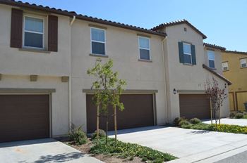 A house with three garage doors and a sidewalk